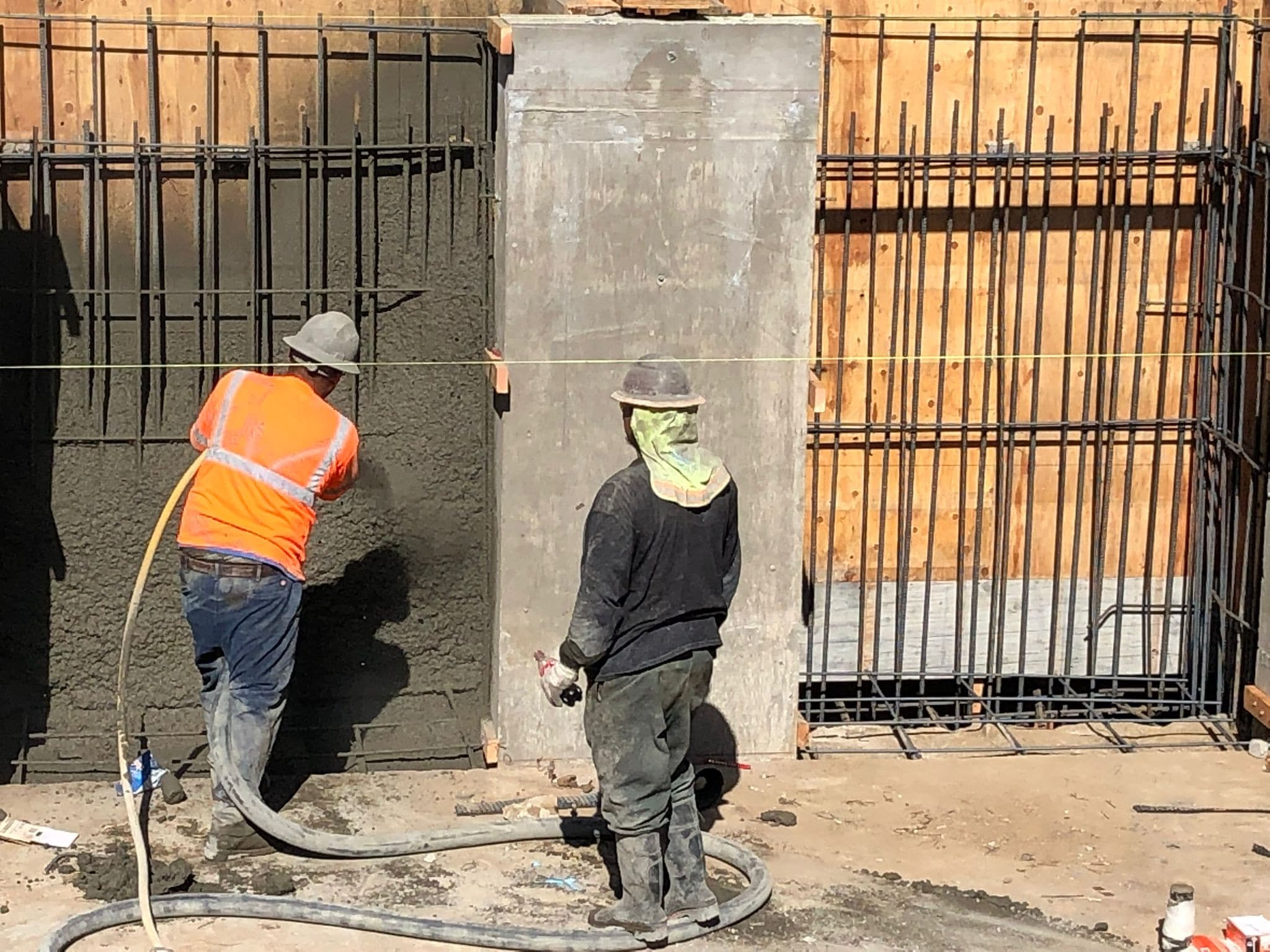 Newly formed concrete retaining and foundation wall with rebar on the hillside lot