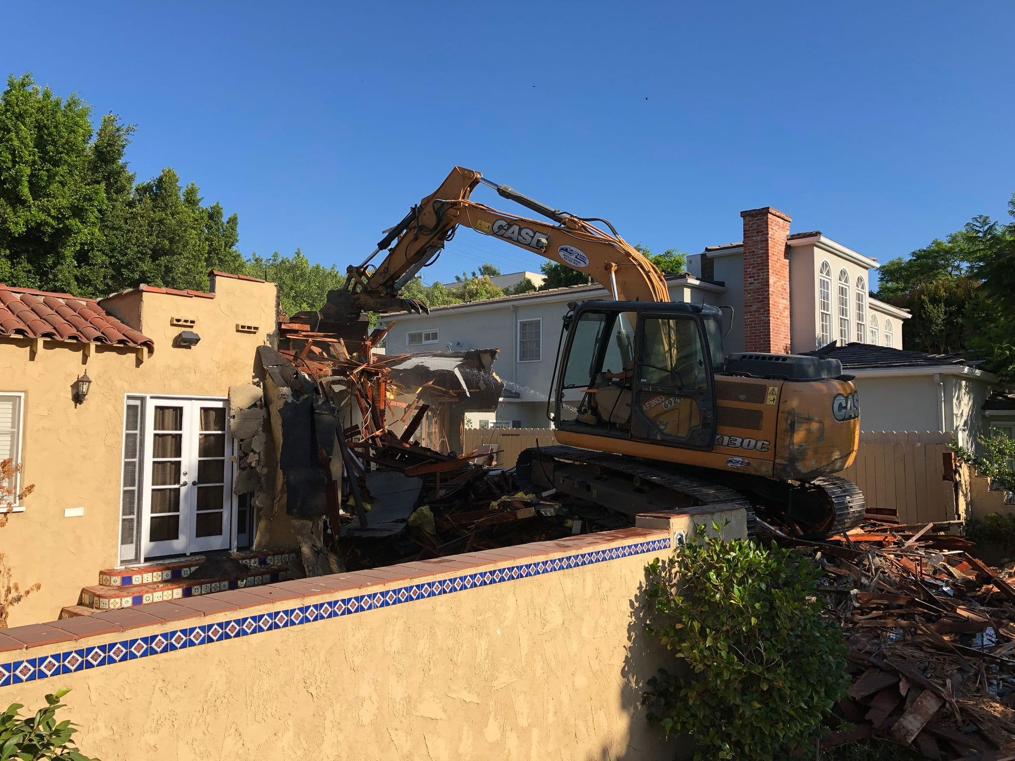 Excavator at the existing older home in West Los Angeles before demolition