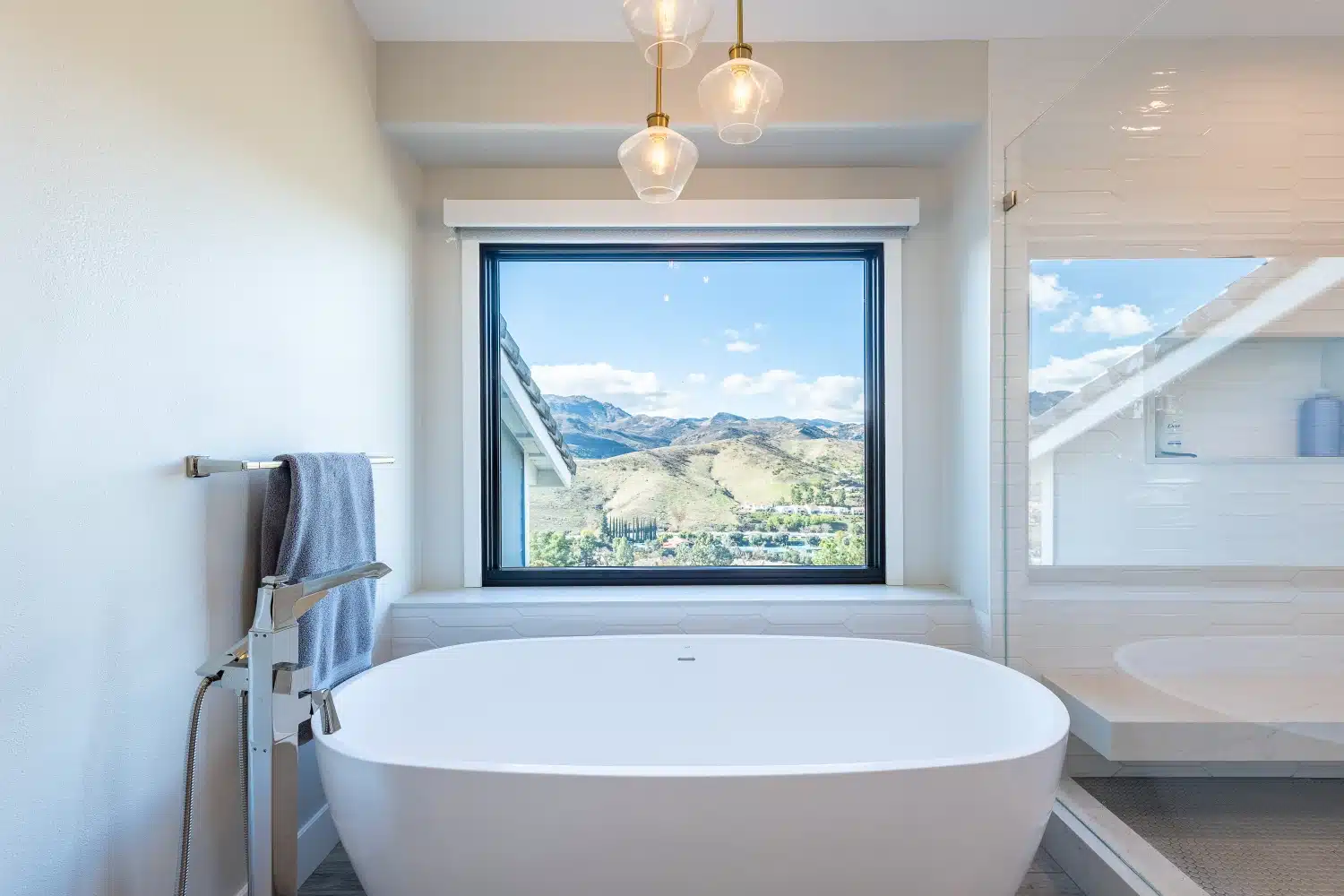 Primary bathroom with freestanding tub and valley view window