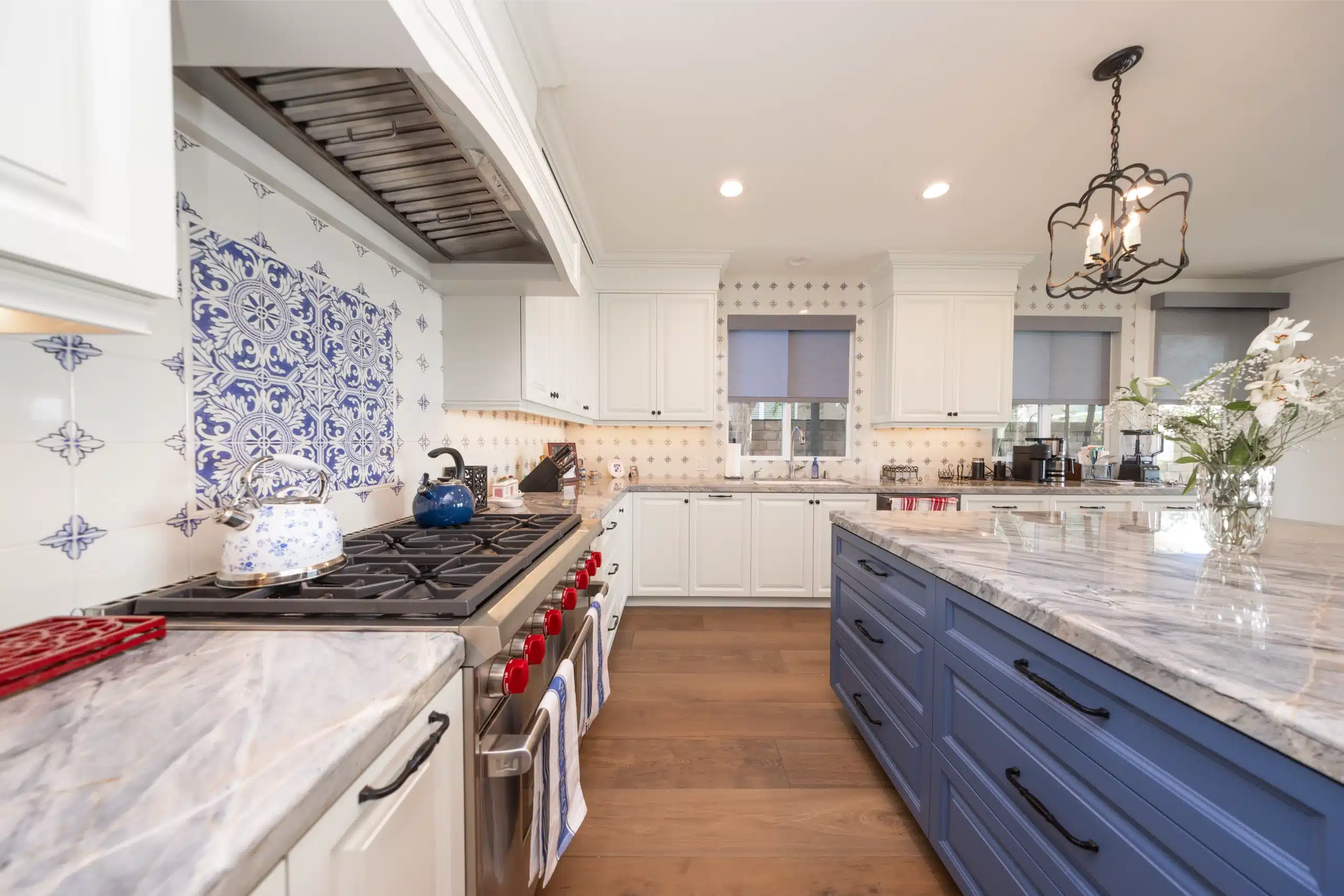 Redesigned kitchen with large island, stone counters, and patterned tile backsplash