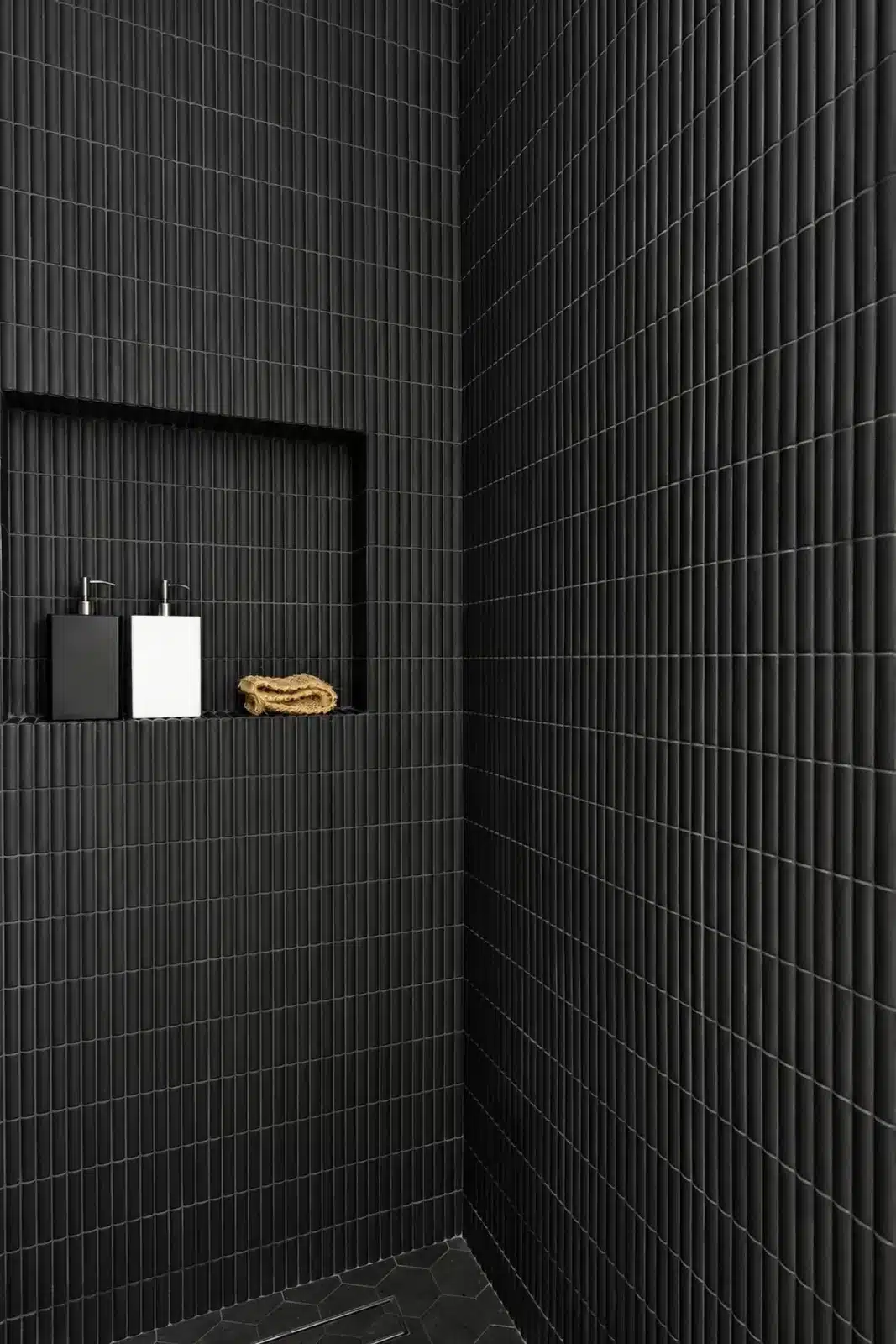 Recessed niche in matte black tile shower