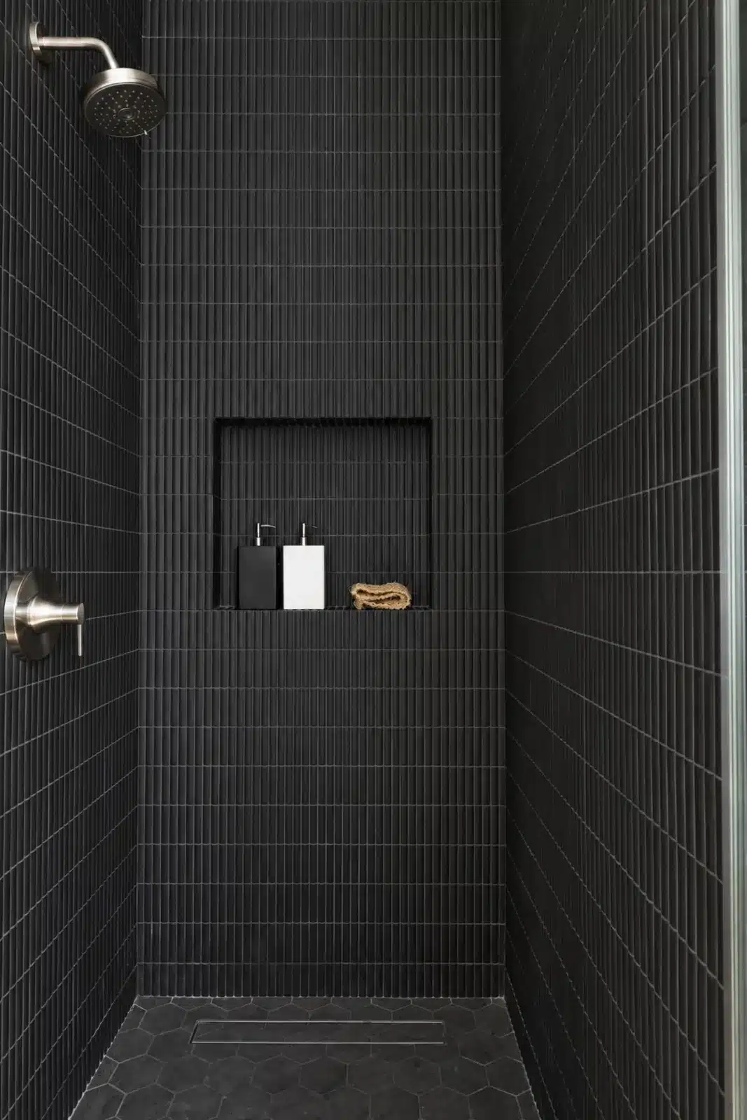 Walk-in shower with matte black vertical tile and linear drain