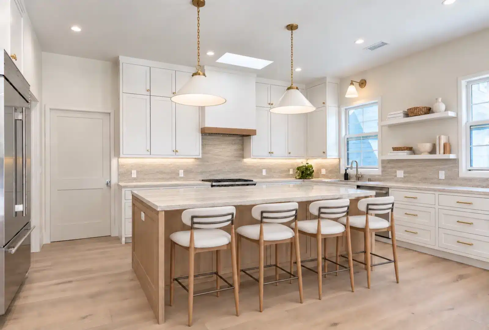Finished kitchen with white shaker cabinets, oak island with four stools and pendant lights