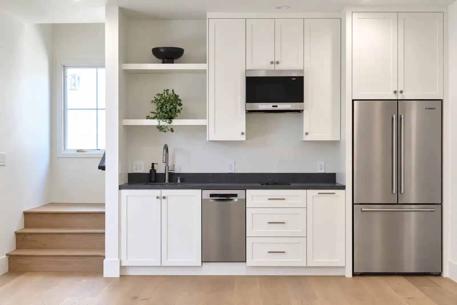 Kitchenette with white shaker cabinets and stainless appliances