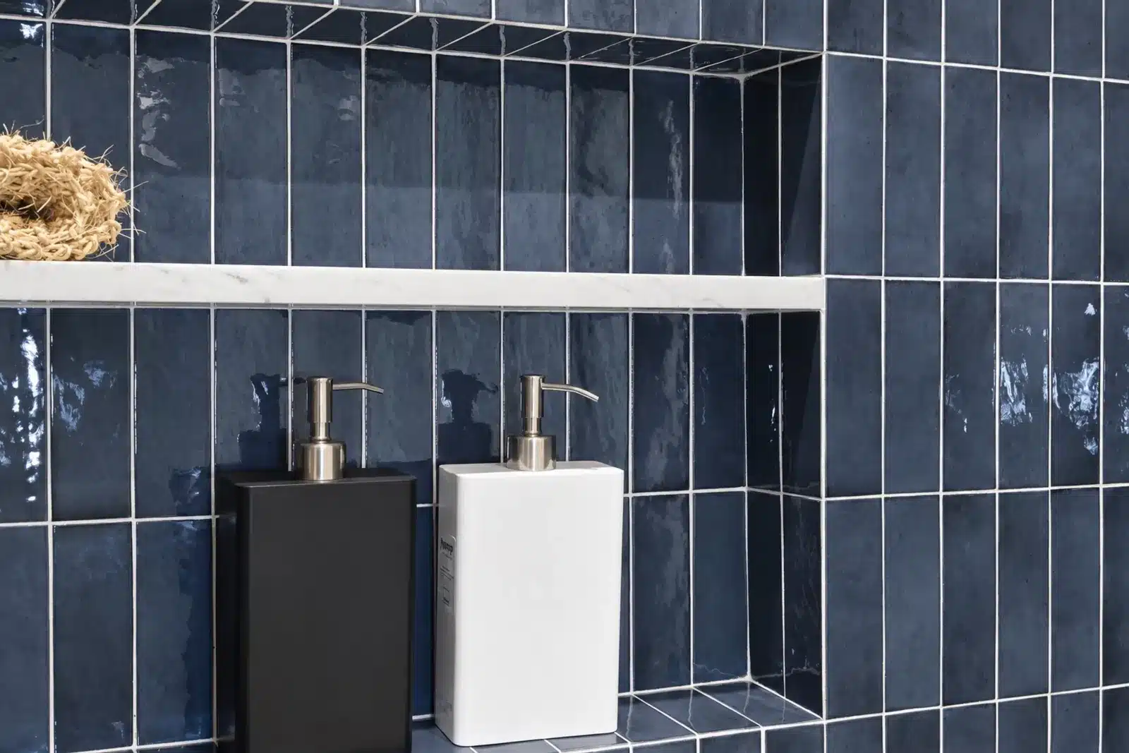 Navy glazed tile shower niche with marble shelf