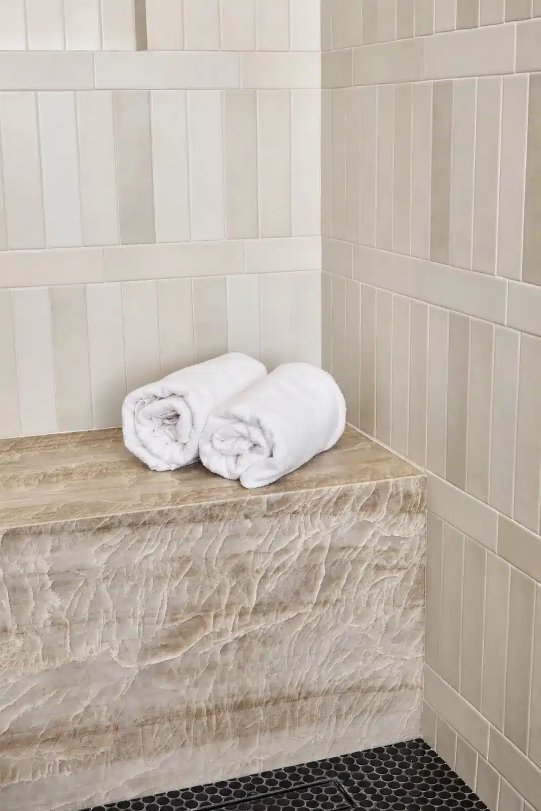 Quartzite shower bench against cream stacked tile
