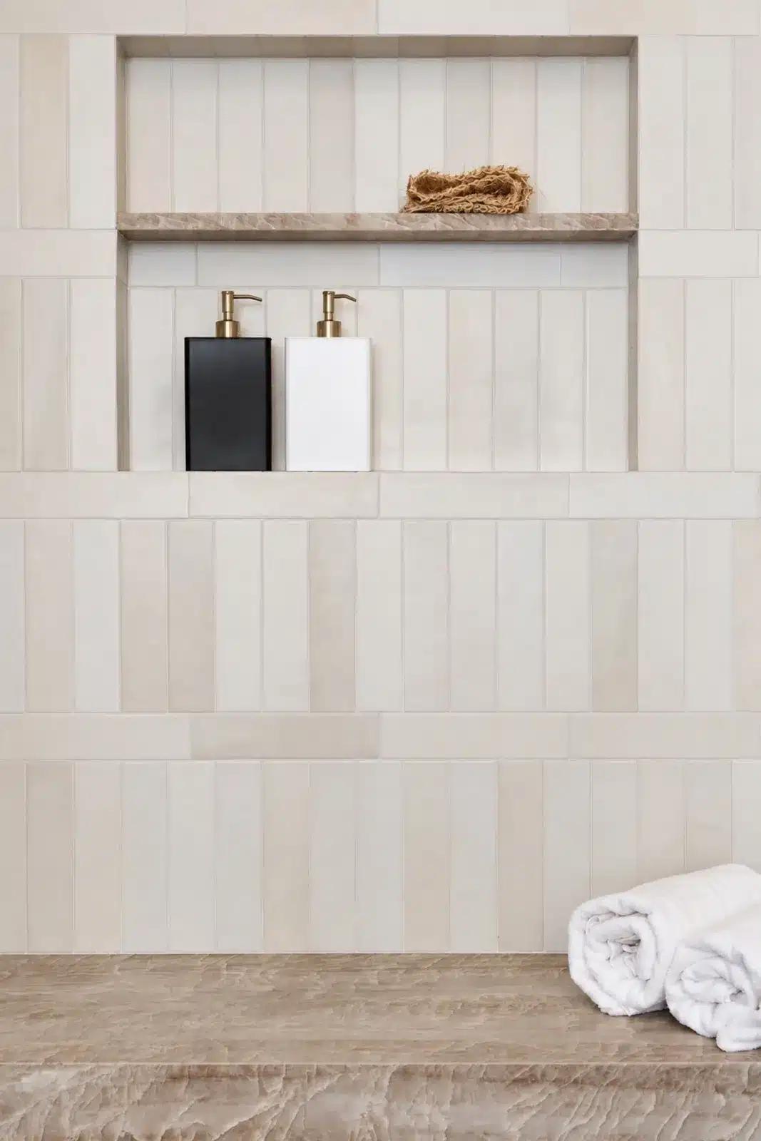 Shower niche in cream stacked tile with quartzite ledge